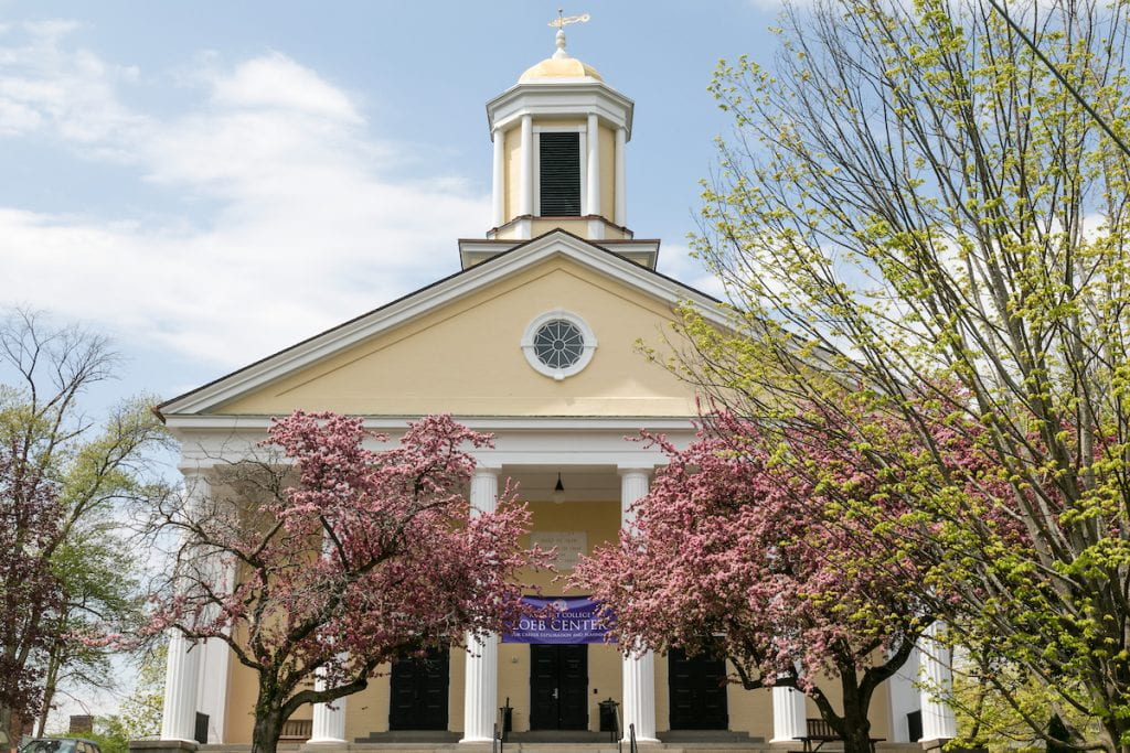 College Hall, a building with columns and a steeple, on a spring day, and a banner saying, Loeb Center for Career Exploration and Planning