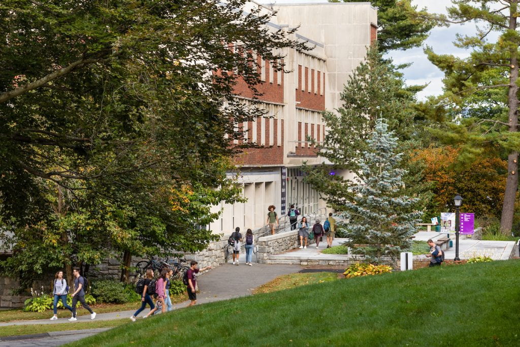 Frost Library entrance, surrounded by trees and students walking